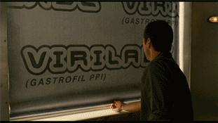 A Man Is Looking Out A Window At A Sign That Says Virulog GIF
