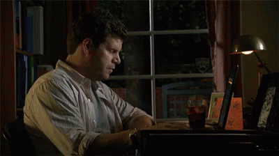 A Man Is Looking Out A Window At A Stuffed Animal That Is Holding A Knife In Its Hand . GIF