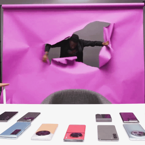 a man is looking through a hole in a purple sheet of paper