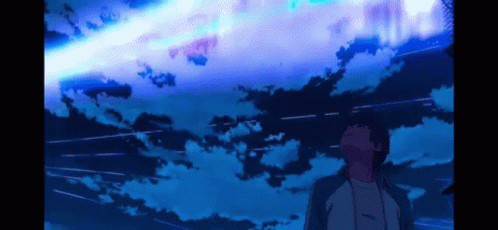 A Man Is Looking Up At A Blue Sky With A Shooting Star GIF