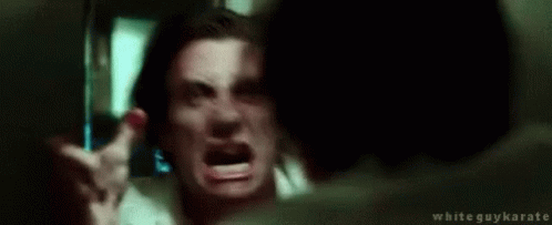 A Man Is Making A Funny Face In Front Of A Mirror And Pointing At Himself . GIF