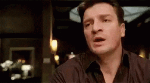 A Man Is Making A Funny Face While Sitting At A Table . GIF