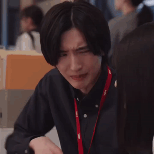 A Man Is Making A Funny Face While Sitting At A Table With His Hands Together . GIF