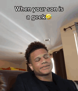 A Man Is Making A Funny Face While Sitting On A Couch With The Caption When Your Son Is A Geek GIF