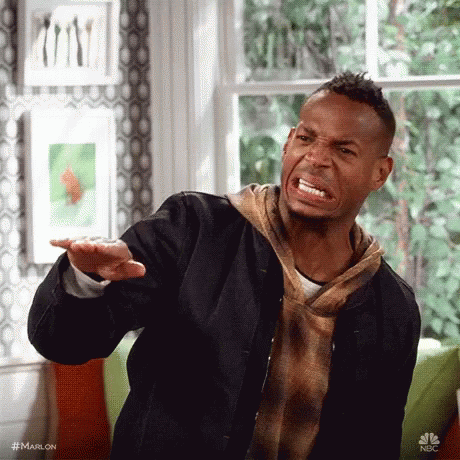 A Man Is Making A Funny Face While Standing In Front Of A Window In A Living Room . GIF