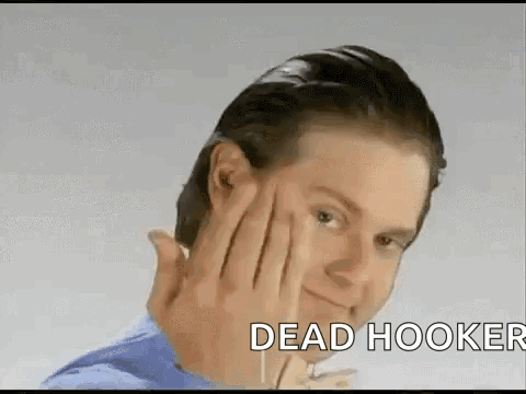 A Man Is Making A Funny Face With His Hand On His Forehead And The Words Dead Hooker Behind Him . GIF