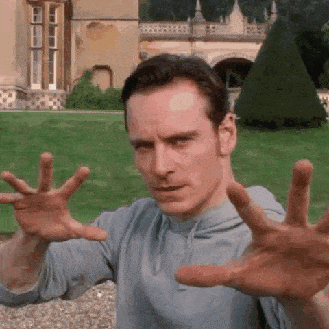 A Man Is Making A Funny Face With His Hands In The Air . GIF
