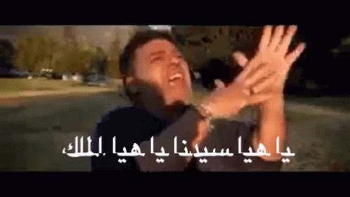 a man is making a funny face with his hands in the air in arabic