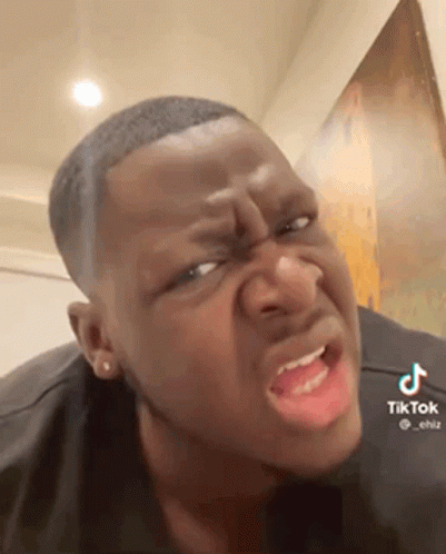 A Man Is Making A Funny Face With His Mouth Open And A Black Shirt On . GIF