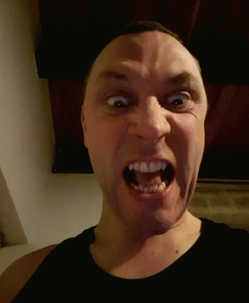 A Man Is Making A Funny Face With His Mouth Wide Open GIF