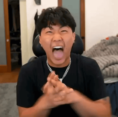 A Man Is Making A Funny Face With His Tongue Out While Wearing A Necklace . GIF