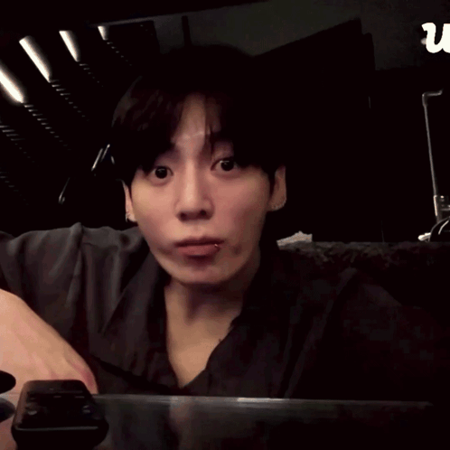 a man is making a heart shape with his hands in front of a sign that says u