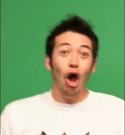 A Man Is Making A Surprised Face In Front Of A Green Background . GIF