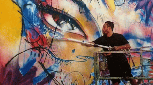 A Man Is Painting A Mural On A Wall With The Letter S On The Bottom GIF