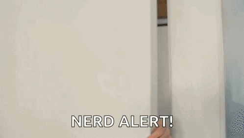 A Man Is Peeking Out From Behind A White Wall And Saying `` Nerd Alert '' . GIF