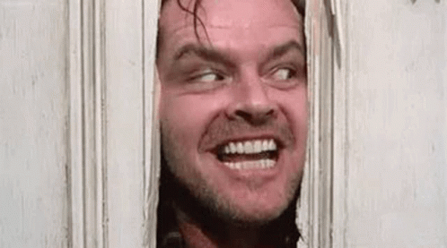 A Man Is Peeking Through A Door With His Mouth Open And Making A Funny Face . GIF