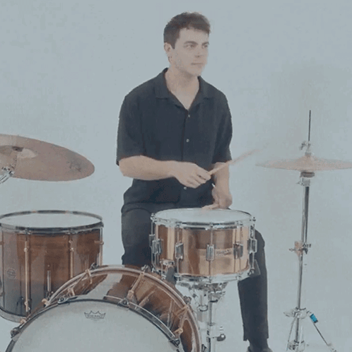A Man Is Playing A Drum Set With A Remo Drum Head GIF