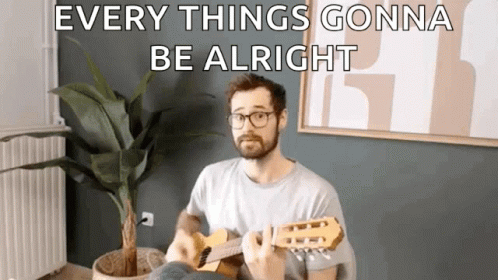 a man is playing a guitar in a living room with a potted plant .