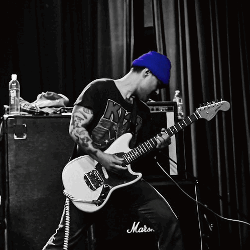A Man Is Playing A Guitar In Front Of A Marshall Amp GIF