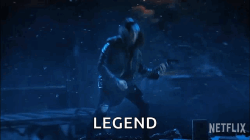A Man Is Playing A Guitar On A Stage In Front Of A Crowd And The Word Legend Is On The Screen . GIF