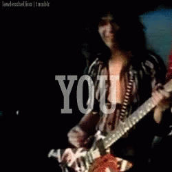 A Man Is Playing A Guitar With The Word You Behind Him GIF