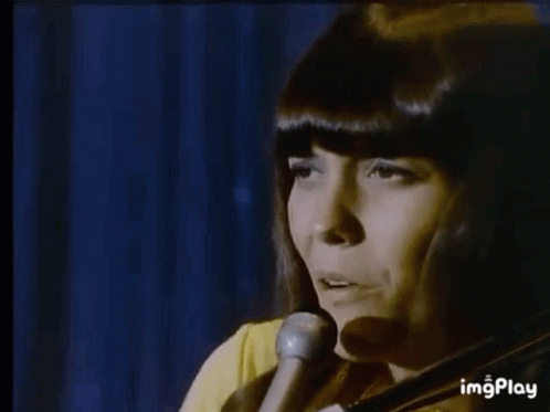 A Man Is Playing A Piano In A Dark Room While Another Man Is Playing Drums In The Background . GIF