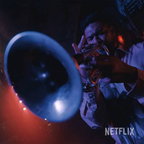 A Man Is Playing A Trumpet With A Netflix Logo In The Background GIF