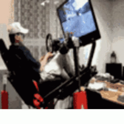 A Man Is Playing A Video Game On A Simulator GIF