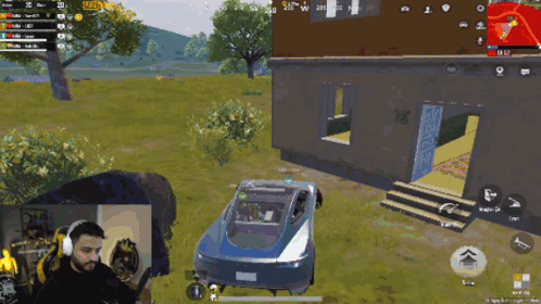 a man is playing a video game with a car in the background