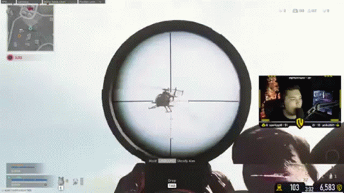 A Man Is Playing A Video Game With A Helicopter In The Scope Of His Sniper Rifle GIF