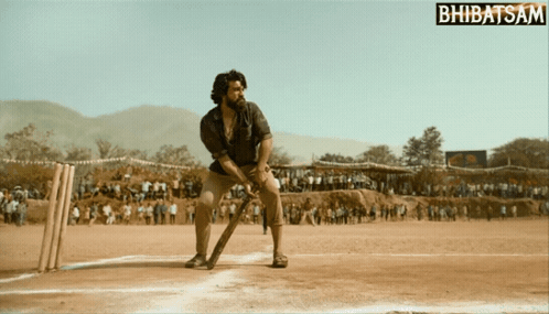 A Man Is Playing Cricket On A Field With A Bhbatsam Logo In The Corner GIF