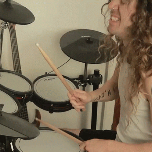 A Man Is Playing Drums With A Shirt That Says ' N.k. ' On It GIF