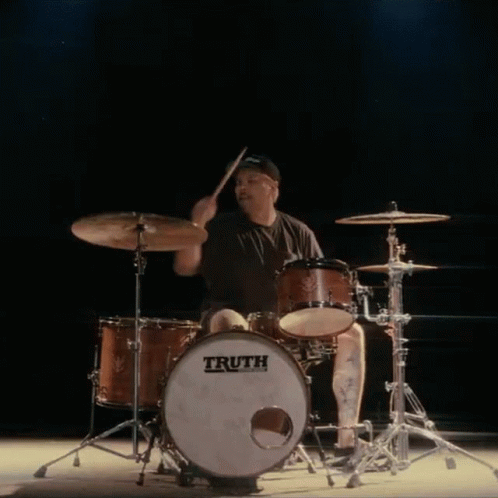 A Man Is Playing Drums With A Truth Drum GIF