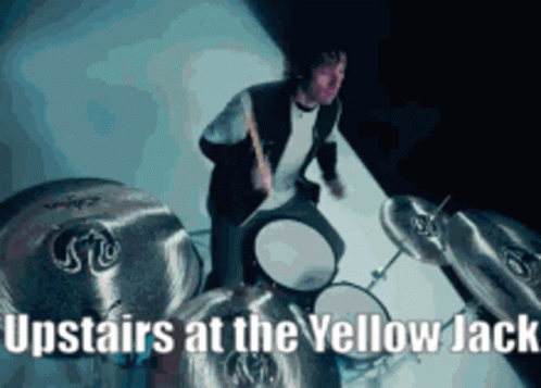 A Man Is Playing Drums With The Words Upstairs At The Yellow Jack GIF