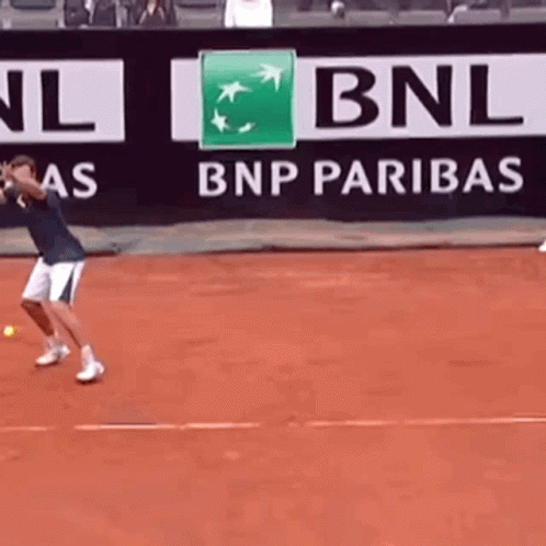 a man is playing tennis in front of a bnp paribas banner