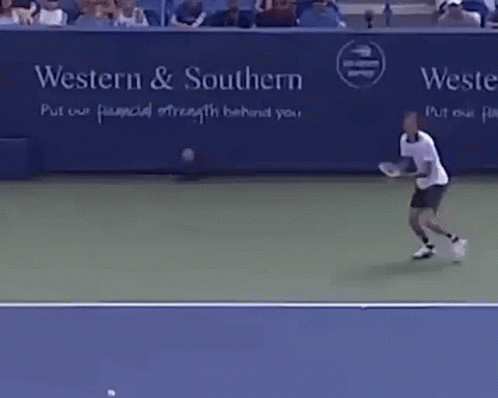 A Man Is Playing Tennis In Front Of A Sign That Says Western & Southern Put Our Financial Strength Behind You GIF