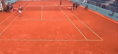 a man is playing tennis on a clay court .
