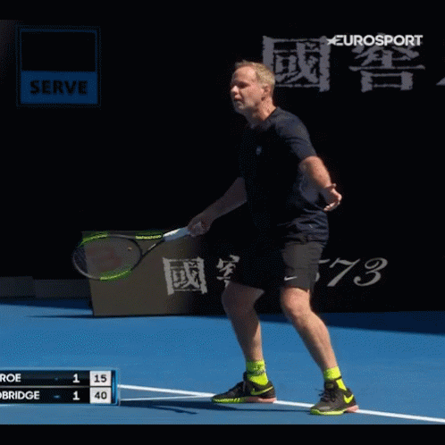 A Man Is Playing Tennis On A Court With A Eurosport Sign In The Background GIF