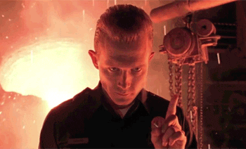 A Man Is Pointing At Something In Front Of A Flame GIF