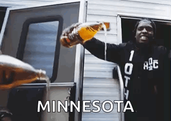 A Man Is Pouring Beer From A Bottle Into A Camper Door . GIF