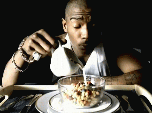A Man Is Pouring Milk Into A Bowl Of Cereal With Roman Numerals On His Arm GIF