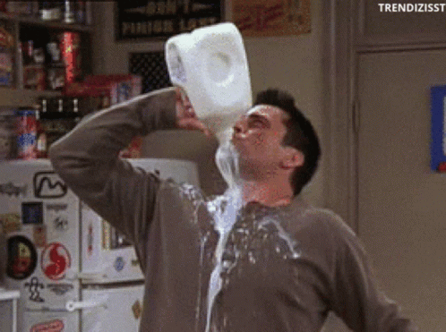 A Man Is Pouring Milk Into His Mouth From A Gallon GIF