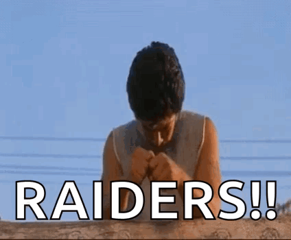 A Man Is Praying For The Raiders While Standing On A Roof . GIF