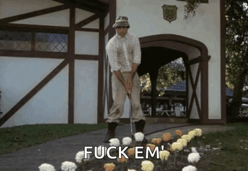 A Man Is Putting A Golf Ball In A Garden With The Words Fuck Em Written On The Ground GIF