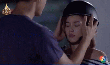 A Man Is Putting A Helmet On A Woman 'S Head With A Hd Logo In The Background GIF