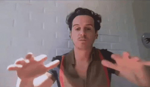 A Man Is Reaching Out His Hands Towards The Camera . GIF