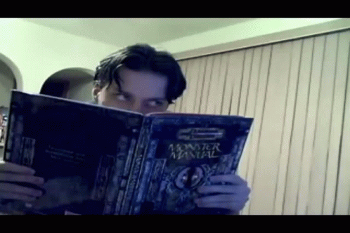 A Man Is Reading A Monster Manual GIF
