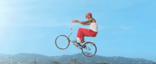 A Man Is Riding A Bicycle In The Air GIF