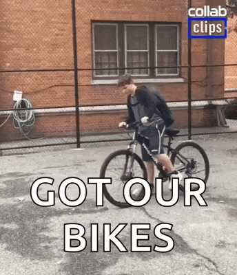 A Man Is Riding A Bike Down A Street With The Words `` Got Our Bikes '' Written On The Bottom . GIF