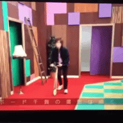 A Man Is Riding A Bike In A Room With Chinese Characters On The Bottom GIF